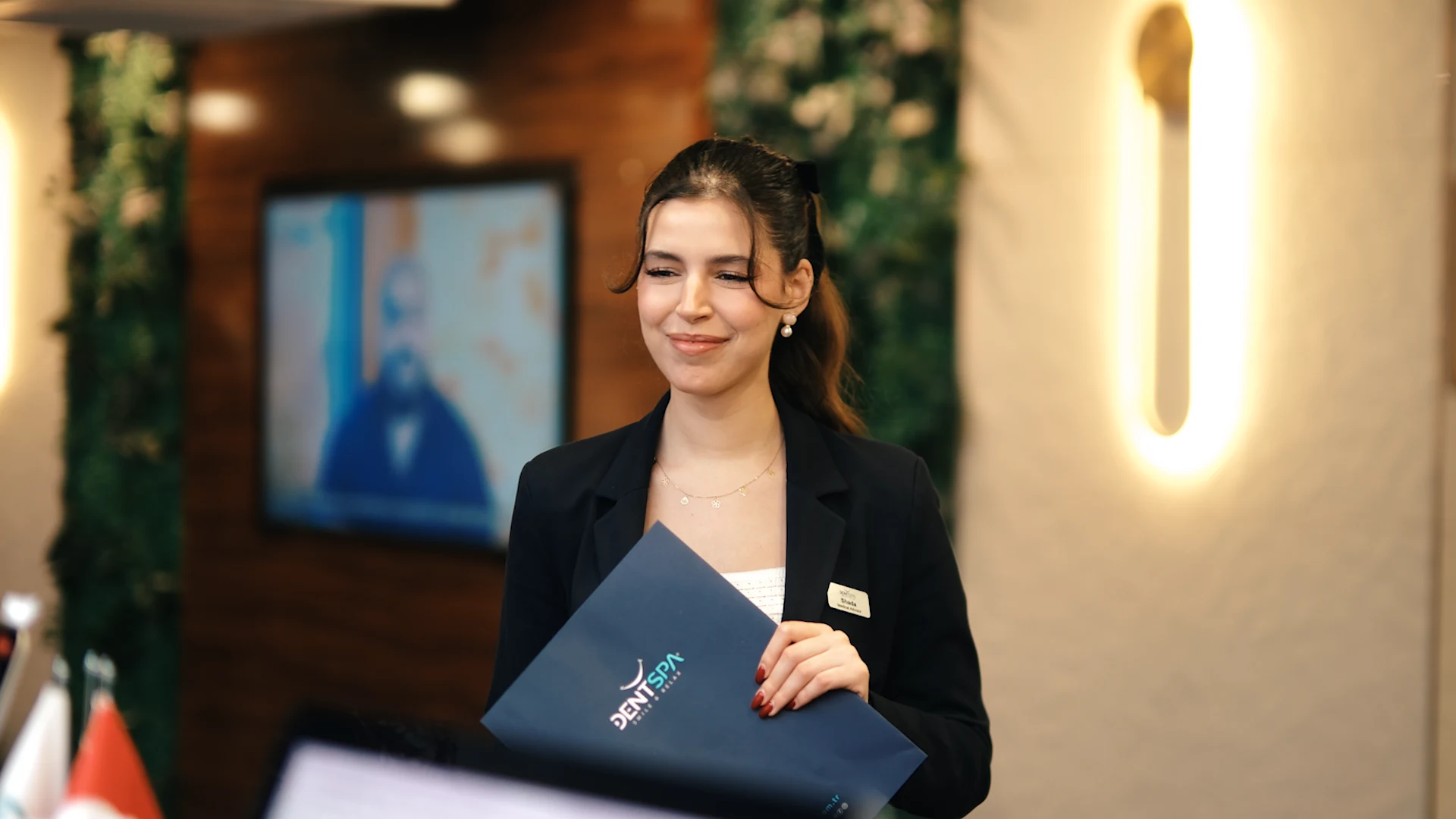 DentSpa patient coordinator holding welcome folder at clinic reception